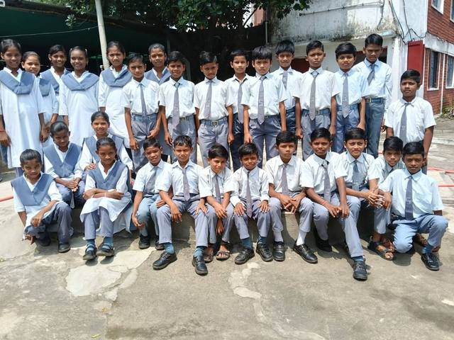 Schulkinder in Uniform vor dem Kinderhaus